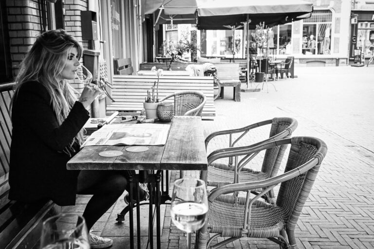 Renske leest een krant op een terras